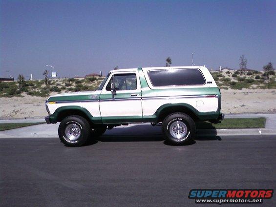White and green 1978 Ford Bronco parked on asphalt, side view