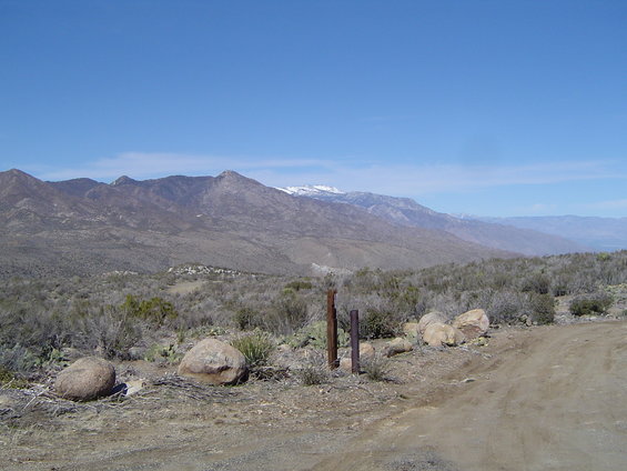 Desert landscape with mountains and a dirt road in the foreground