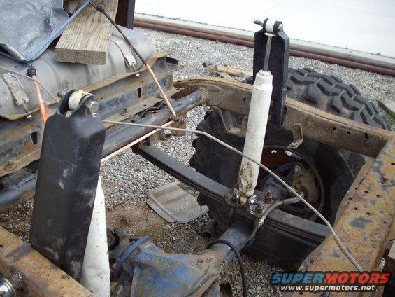 close-up of rusty vehicle frame with leaf springs and shocks
