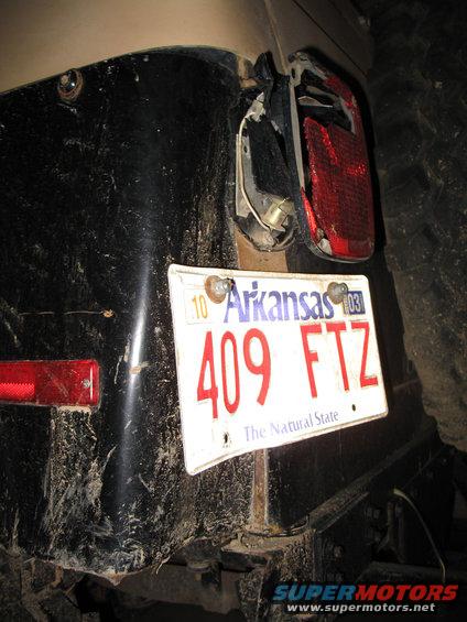 Rear of a dirty vehicle with a broken taillight and an Arkansas license plate that reads 409 FTZ