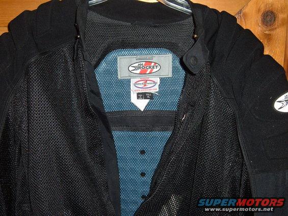Inside of a black Joe Rocket motorcycle jacket with mesh lining and tags visible