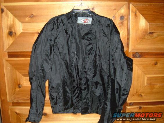 Black Joe Rocket motorcycle jacket hanging on a wooden door