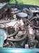 1995 Ford Bronco - The engine bay of a green vehicle, showing various mechanical parts and hoses.