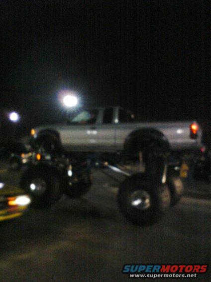 Silver lifted pickup truck with oversized tires, side view