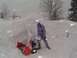 2000 Chevrolet Tahoe - A person operates a snow blower in heavy snowfall, clearing a path through deep snow.