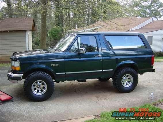Dark green 1995 Ford Bronco side view with aftermarket wheels