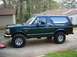 1995 Ford Bronco - This 1995 Ford Bronco features a dark green exterior and aftermarket wheels, viewed from the side.
