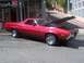 1972 Ford Ranchero - A red 1972 Ford Ranchero is parked on a street with its hood open, in front of a Quiksilver store.
