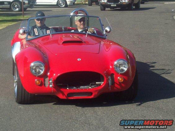 Red convertible sports car with two occupants, front view