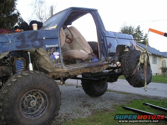 Blue off-road vehicle with large tires, open doors, and visible "Bronco II" badging