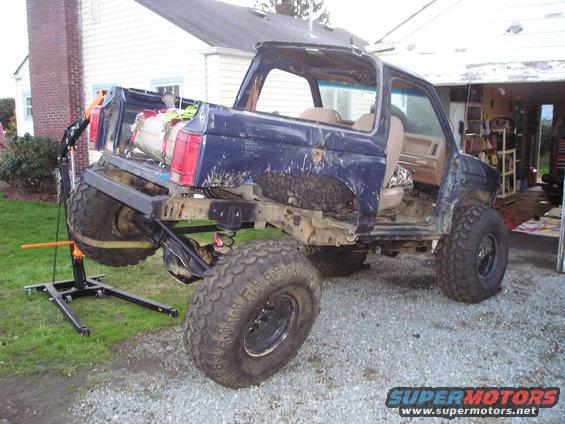 Blue 1986 Ford Bronco II with lifted suspension and large tires, rear quarter view