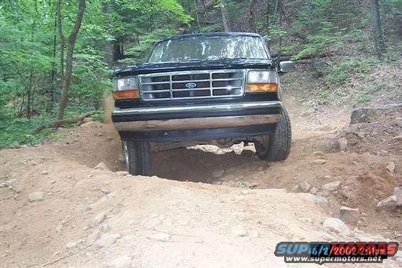 Black 1995 Ford Bronco front view driving off-road on a dirt path