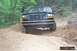 1995 Ford Bronco - This 1995 Ford Bronco navigates a challenging off-road trail, demonstrating its capability on rough terrain.