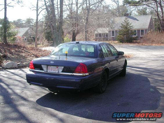 Rear view of a dark blue sedan parked on asphalt. License plate reads 81BD23