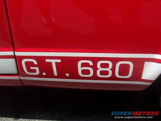Red car side panel with white stripe and G.T. 680 text