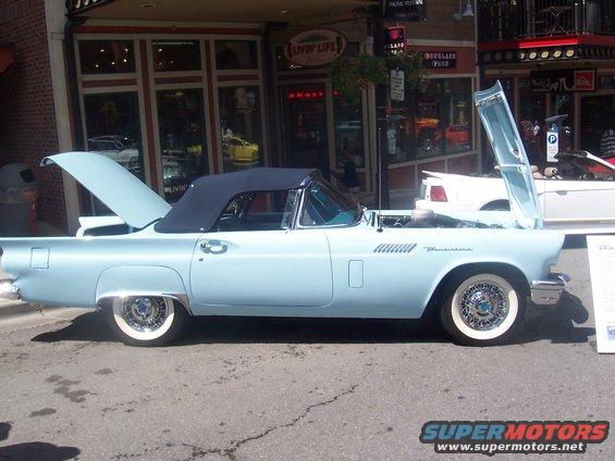 Light blue convertible with black top, hood and trunk open. Whitewall tires and wire wheels