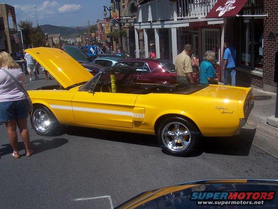 Yellow 1968 Ford Mustang convertible with hood open, California Special badging on rear quarter panel