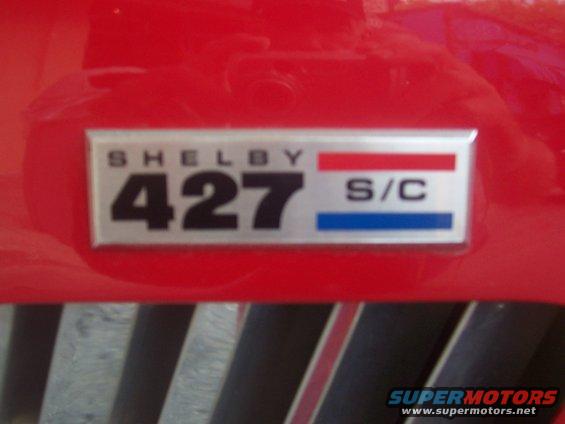 Shelby 427 S/C emblem on red car body, above black grille