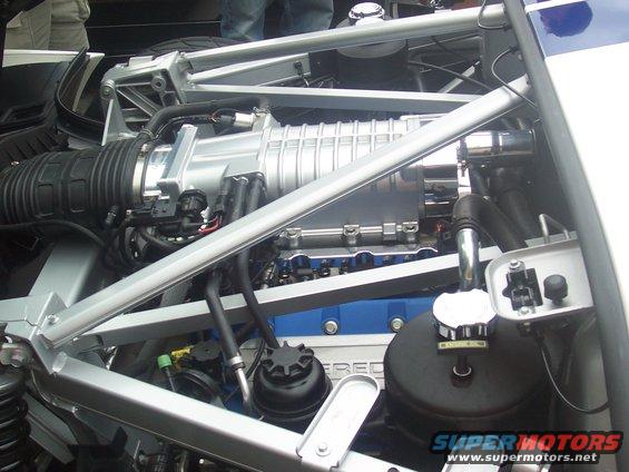 Close-up of a supercharged V8 engine with blue valve covers and silver intake manifold