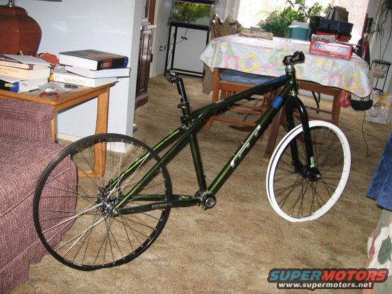 Green bicycle frame with front and rear wheels attached