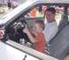 1993 Ford Mustang - A young boy pretends to drive a 1993 Ford Mustang while a man watches him from the passenger seat.