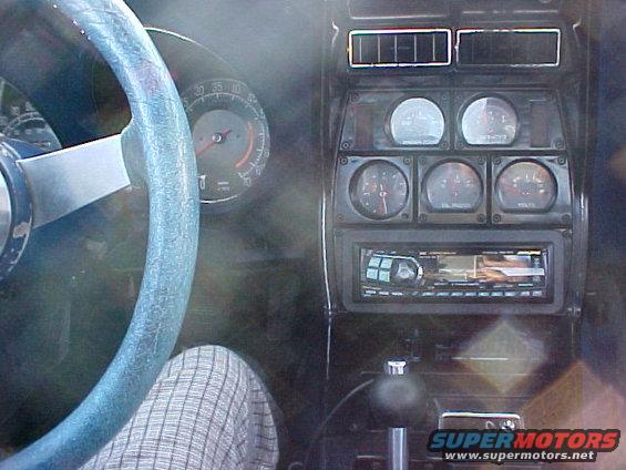 car dashboard with steering wheel, gauges, and radio