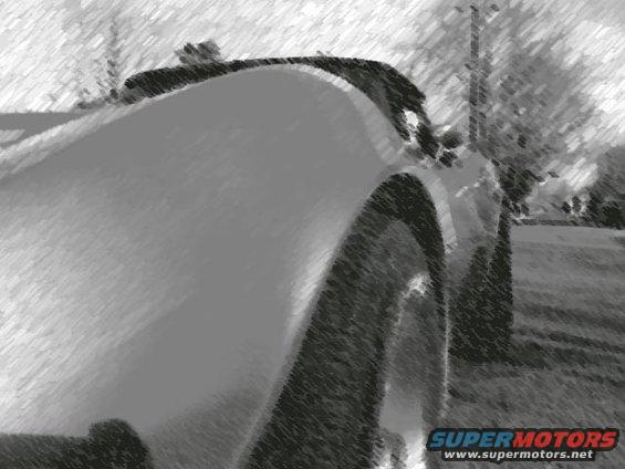 Close-up of a car's rear fender and wheel. Text at bottom says SUPERMOTORS