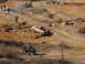 1991 Ford F-150 - Multiple off-road vehicles navigate a challenging dirt track with spectators observing the action.