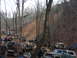 1991 Ford F-150 - A group of off-road vehicles and people are gathered in a wooded area with a muddy slope.