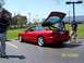 1996 Ford Probe - A red Ford Probe is parked with its trunk open, with two people standing nearby on a sunny day.