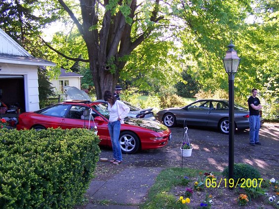 1996 Ford Probe in red with hood open, another gray Probe behind it in driveway