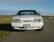 1993 Ford Mustang - White 1993 Ford Mustang parked on an asphalt road with a grassy field in the background.