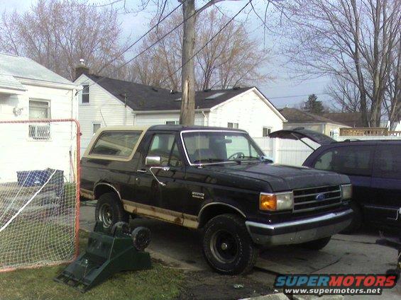Black 1990 Ford Bronco with tan top parked in driveway