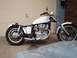 1978 Honda CB500T - A custom motorcycle with a white tank and exposed engine is parked in front of a garage door.