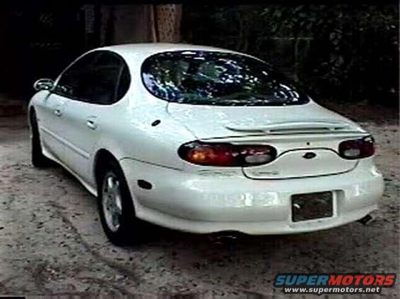 White sedan, rear 3/4 view, with a spoiler and tinted windows