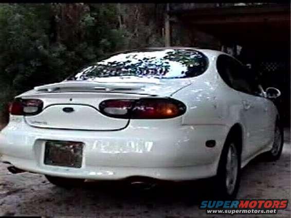 White 1997 Ford Taurus rear view with snow on the windshield