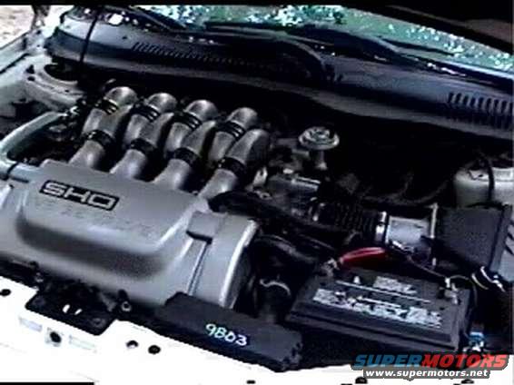 Engine bay of a 1997 Ford Taurus SHO, showing the V8 engine, intake manifold, and battery
