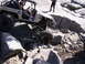 1989 Ford Bronco - An off-road vehicle tackles a challenging rocky path with a second vehicle visible in the background.