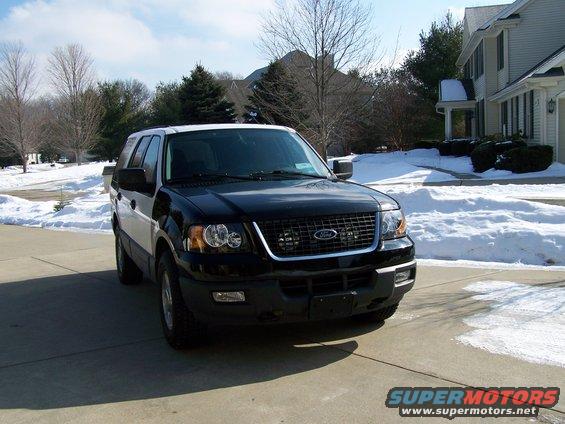Black and white Ford Expedition parked on a driveway in the snow