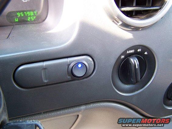 2004 Ford Expedition interior showing odometer reading 95798.7, temperature 25 degrees, 4WD selector dial, and an illuminated auxiliary switch