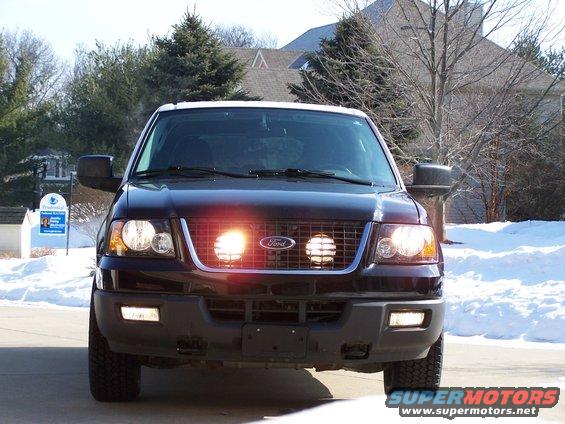 Front view of a black 2004 Ford Expedition with auxiliary lights on