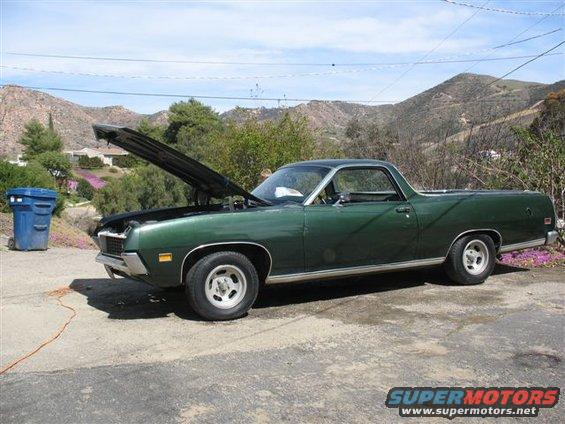 Green 1970s pickup truck with hood open, side view