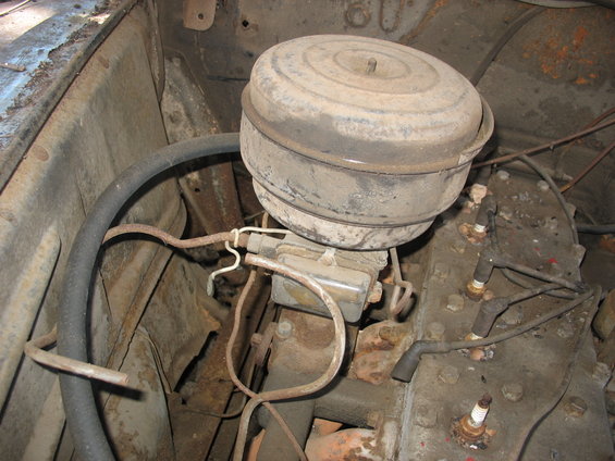 Engine bay detail showing carburetor, air cleaner, spark plugs, and wiring