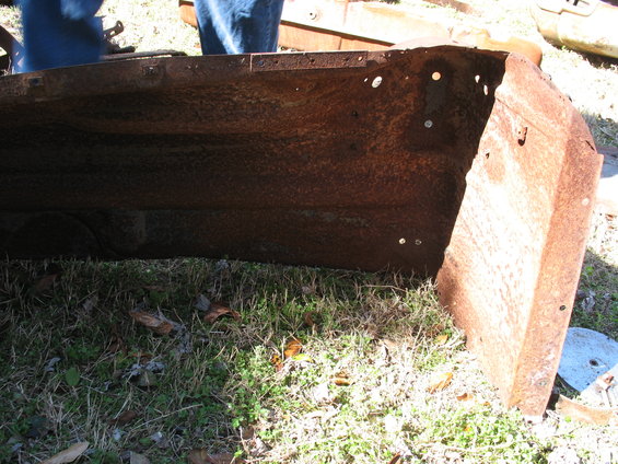 rusted metal corner of a truck bed, showing interior bracing and mounting holes