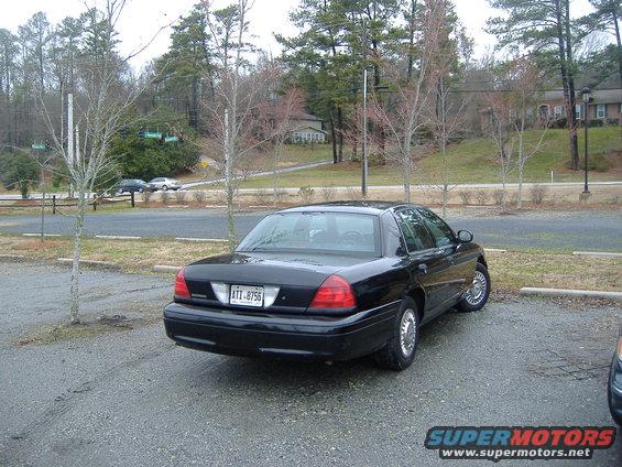 Black 2001 Ford Crown Victoria parked on gravel lot. License plate ATT-8756