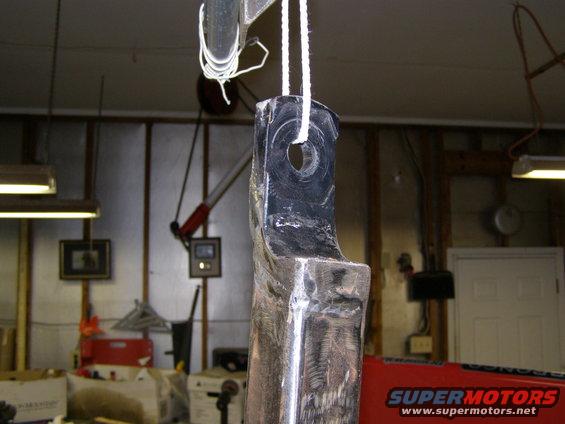 Metal bracket hanging from rope, showing signs of wear and repair
