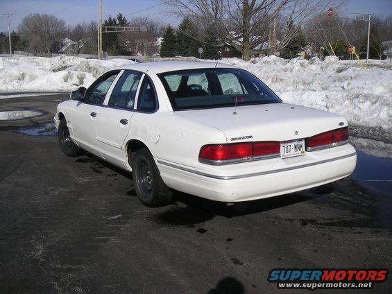 Rear view of a white 1997 Ford Crown Victoria sedan in a snowy lot