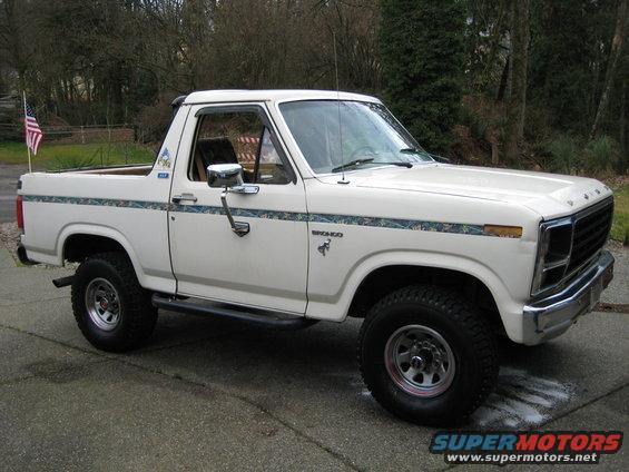 White Ford Bronco with camouflage stripe, side view, parked on asphalt