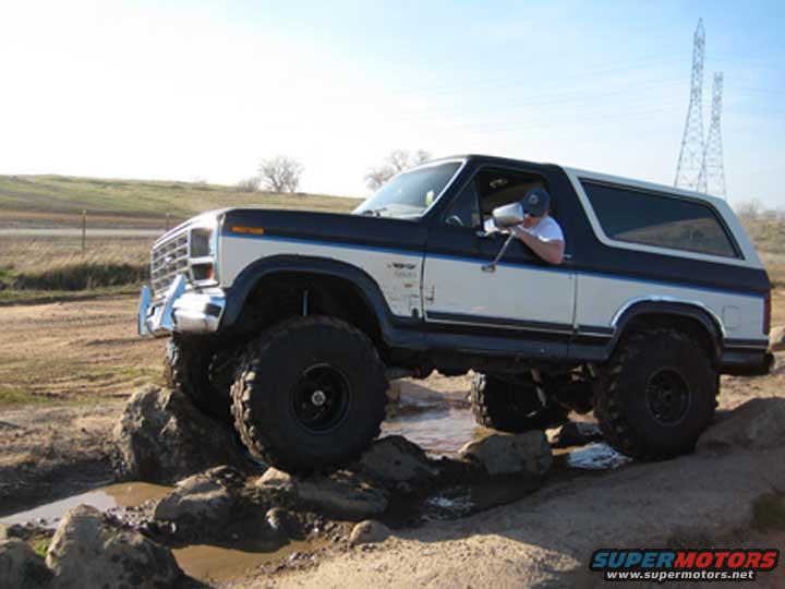 1978 Ford Bronco navigating rocks and water on an off-road trail