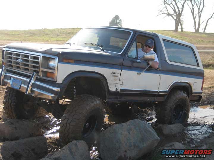 Ford Bronco driving over rocks and mud